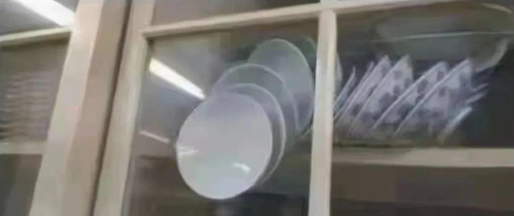 橱柜中倾倒并紧贴柜门的盘子